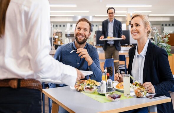 Man and women eat lunch in canteen